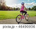 Girl in a helmet riding a bicycl in summer park 46490936