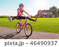 Girl in a helmet riding a bicycle in summer park 46490937