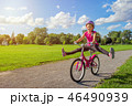 Girl in a helmet riding a bicycle in summer park 46490939