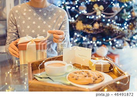 No face young woman opening Christmas present No face young woman opening Christmas present 46491872