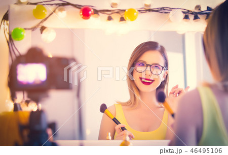 blogger woman applying cosmetics at camera  46495106