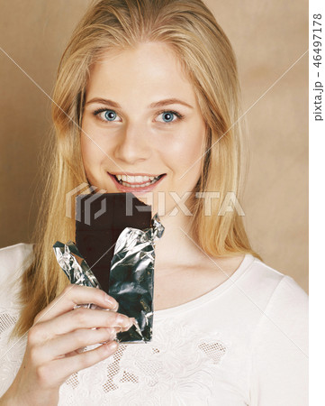 young cute blond girl eating chocolate and drinking coffee close 46497178