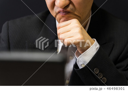 頬杖をついて、しかめっ面する無精髭のビジネスマン 46498301