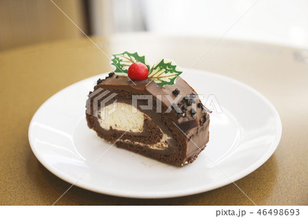 Cake chocolate roll and sweet cream in white plate 46498693