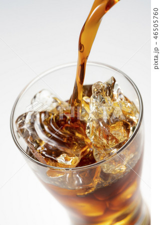 グラスにアイスコーヒーを注ぎ入れるの写真素材