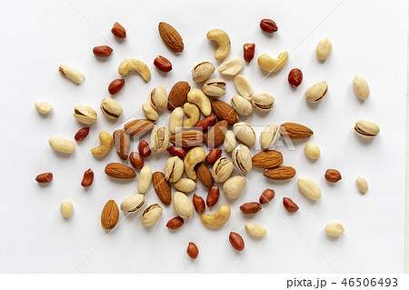 Assorted roasted and raw nuts scattered on white Assorted roasted and raw nuts scattered on white 46506493