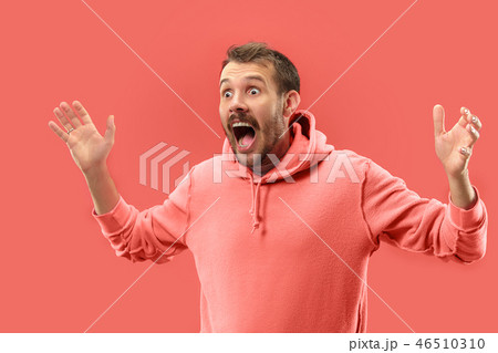The young attractive man looking suprised isolated on coral background 46510310