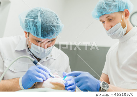 Doctor used microscope. Dentist is treating patient in modern dental office. Operation is carried 46510970