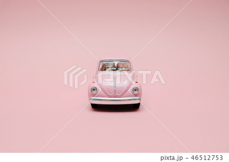 Pink retro toy car delivering bouquet of flowers Pink retro toy car delivering bouquet of flowers 46512753