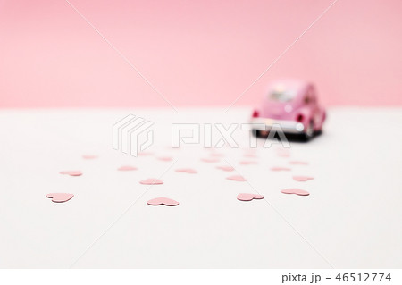 Pink retro toy car delivering bouquet of flowers 46512774
