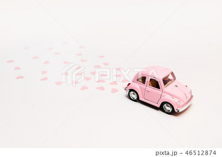 Pink retro toy car delivering bouquet of flowers Pink retro toy car delivering bouquet of flowers 46512874