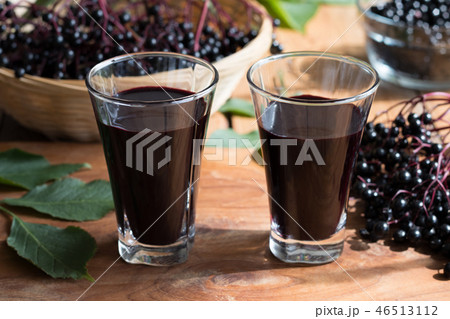 Two glasses of elderberry syrup on a table 46513112