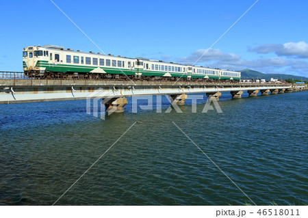 男鹿線 夏の船越水道を渡る普通列車の写真素材