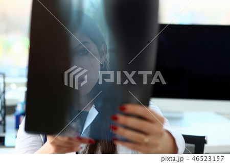 Female beautiful doctor hold in arm and look at xray Female beautiful doctor hold in arm and look at xray 46523157