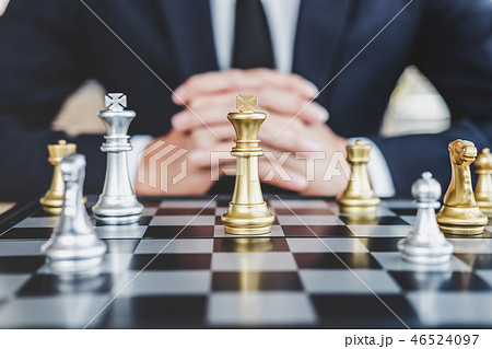 Businessman playing chess game reaching to plan strategy for suc 46524097