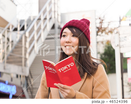 TOKYOのガイドブックを持って微笑む女性 TOKYOのガイドブックを持って微笑む女性 46524396