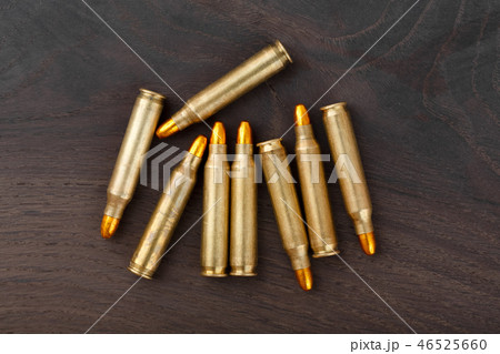 Bullets on wood background. A group of bullets for a gun on wood background. 46525660