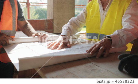Supervisor Showing Building Plans To Workers In New House Supervisor Showing Building Plans To Workers In New House 46528223