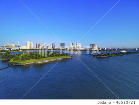 レインボーブリッジのプロムナードから見た台場公園の芝生広場と海浜公園の海揃いのビル群の風景写真。 レインボーブリッジのプロムナードから見た台場公園の芝生広場と海浜公園の海揃いのビル群の風景写真。 46530721