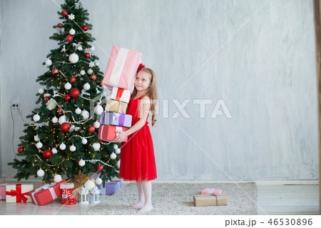 little girl opens Christmas presents new year tree little girl opens Christmas presents new year tree 46530896