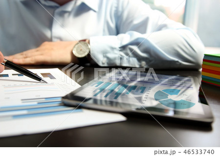 Man working and analyzing financial figures.Tablet 46533740