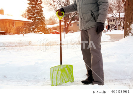 Man shoveling and removing snow in the suburb Man shoveling and removing snow in the suburb 46533961