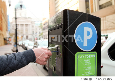 man is paying his parking. Pay station terminal 46534365
