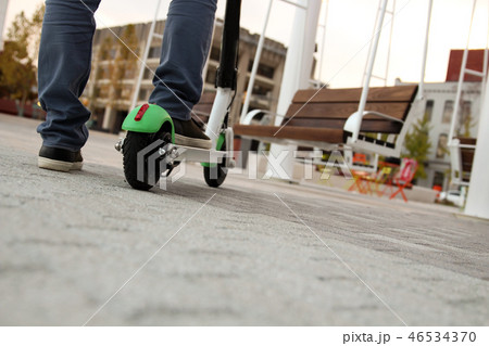 Close up image of a man on an electric scooter. 46534370