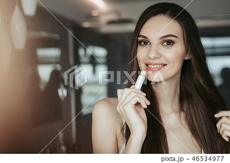 Happy female applying makeup in the apartment 46534977