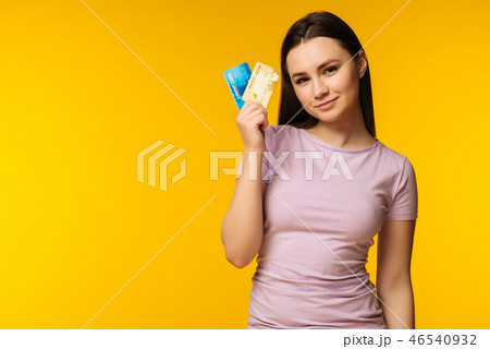 Happy woman holding and showing credit card Happy woman holding and showing credit card 46540932