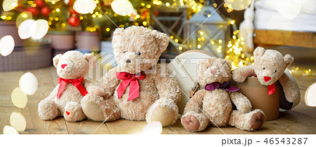 Family of teddy bears siting under the christmas tree with presents. Long banner 46543287