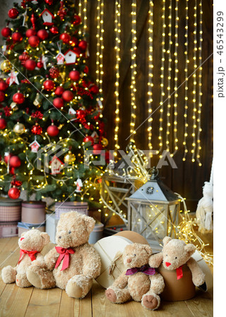 Family of teddy bears siting under the christmas tree with presents 46543299