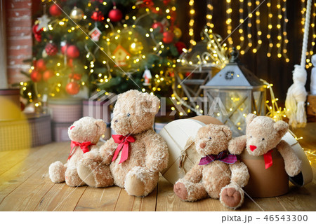 Family of teddy bears siting under the christmas tree with presents 46543300