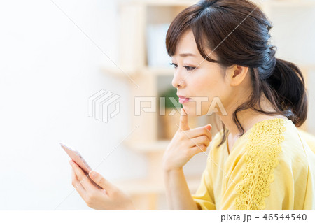 スマホを操作する女性 不安そうな母親 ミドル女性 専業主婦 スマホを操作する女性 不安そうな母親 ミドル女性 専業主婦 46544540