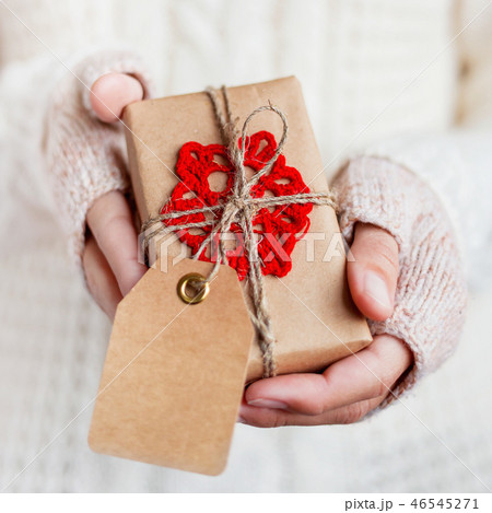 Woman in knitted sweater holding present Woman in knitted sweater holding present 46545271