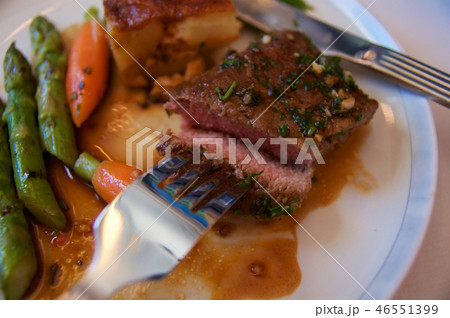 SINGAPORE, - JULY 22, 2016: grilled lamb fillet in Rosmarinjus with carrots, asparagus, cherry 46551399