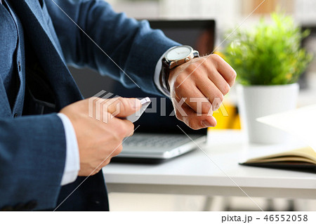 Man in suit and tie check out time at silver wristwatch Man in suit and tie check out time at silver wristwatch 46552058