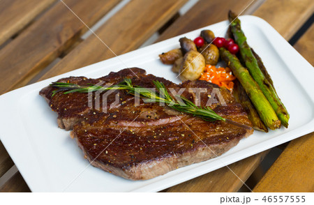 Roasted veal steak on wooden background 46557555