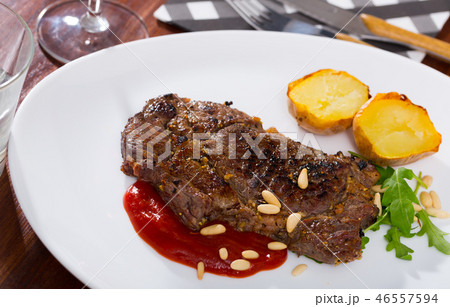 Well done fried beef loin with tomato sauce and pine nuts 46557594