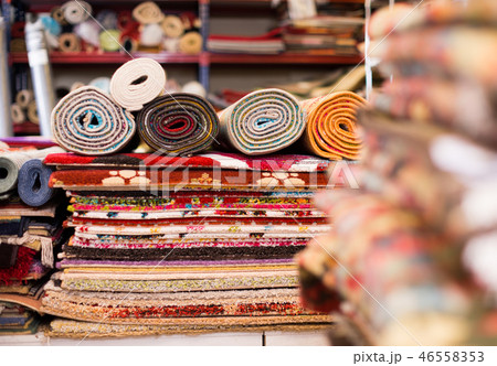 Carpets of different colours in stack at carpet store 46558353