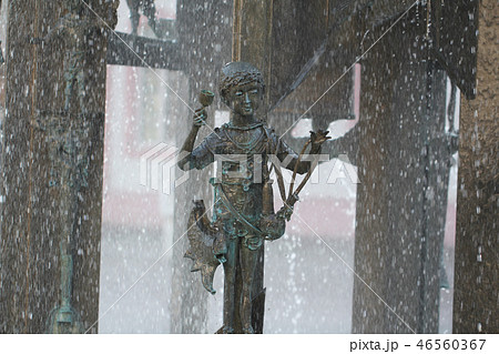 Metal young kid statue play rain water germany mai 46560367