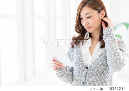 部屋でタブレットを見る女性 46561214