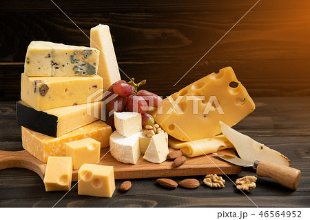 Various types of cheese on a rustic table 46564952