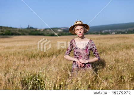 a woman farmer in hat on the field of ripe wheat harvest 46570079