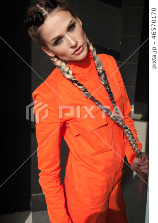 beautiful fashionable woman with braids in Orange overalls beautiful fashionable woman with braids in Orange overalls 46570170