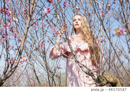 beautiful blonde woman in pink flower garden 46570587