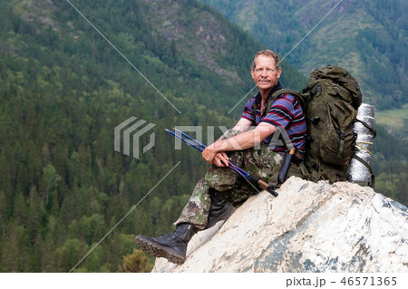 A tourist on a high mountain looks at nature. 46571365