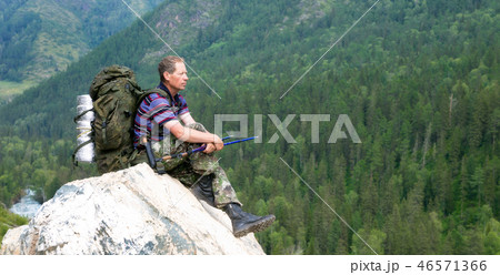 A tourist on a high mountain looks at nature. A tourist on a high mountain looks at nature. 46571366