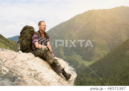 A tourist on a high mountain looks at nature. A tourist on a high mountain looks at nature. 46571367