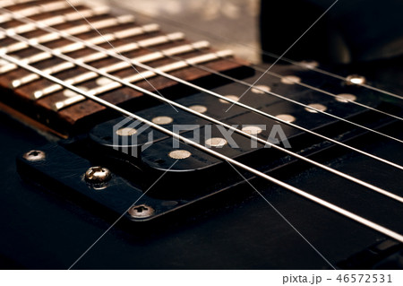 Wooden neck of a black guitar close up Wooden neck of a black guitar close up 46572531